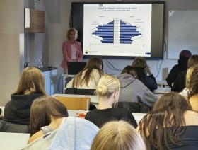 zdjęcie uczniów w klasie, patrzących na tablicę z prezentacją